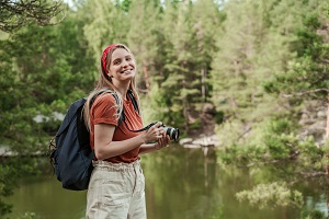 mloda dziewczyna z aparatem fotograficznym w lesie