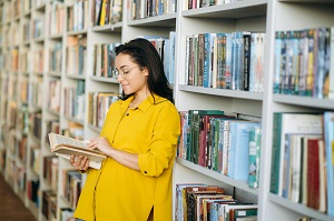 kobieta czyta ksiazke w bibliotece