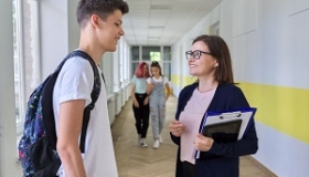 nauczycielka rozmawia z uczniem na korytarzu szkolnym