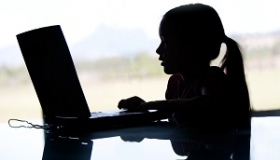 ciemna sylwetka dziecka korzystajacego z internetu