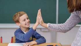 uczen przybja piatke z nauczycielem