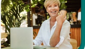 usmiechnieta kobieta przy biurku z laptopem