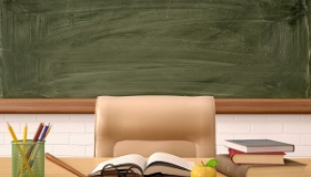 biurko nauczyciela na tle tablicy w klasie szkolnej